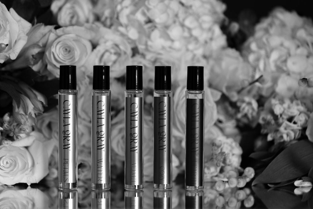 Rollerballs in a line in front of flowers