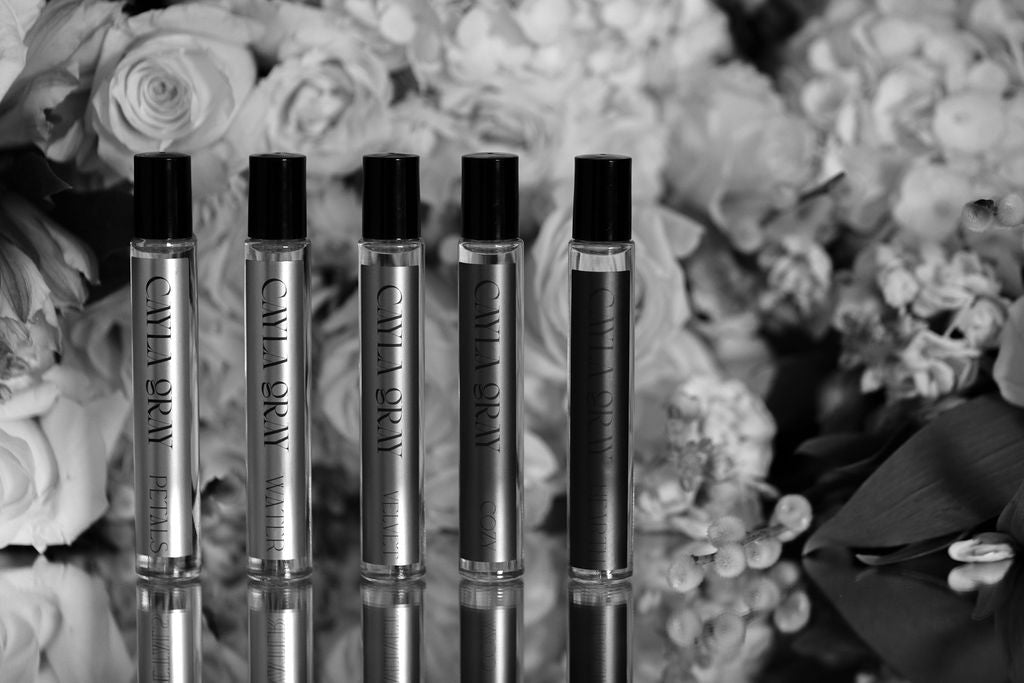 Cayla Gray rollerballs in front of flowers